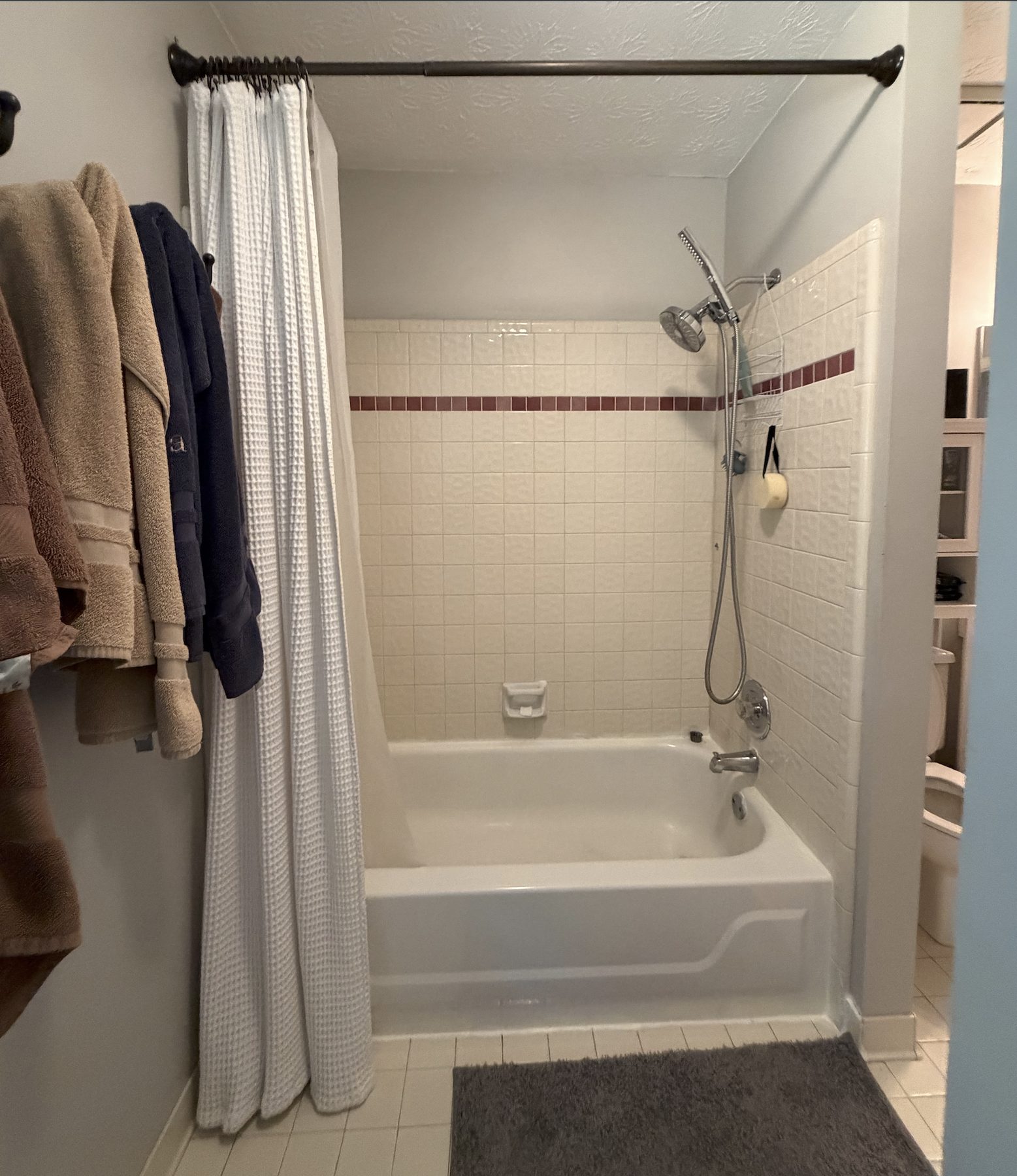Lisa & Alex bathroom — before photo of existing tub and shower with maroon tile band
