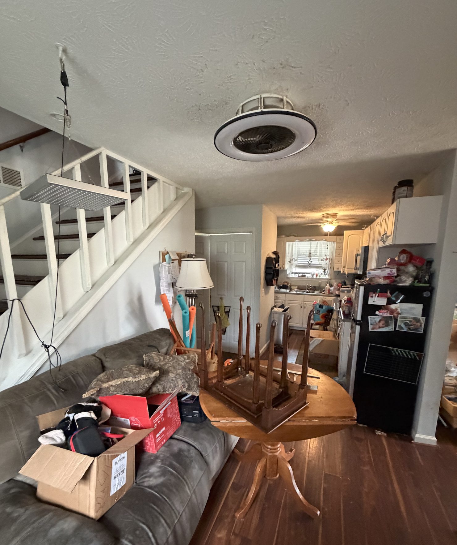 Lanier — before interior, original kitchen and stair view with popcorn ceiling and white-spindle staircase